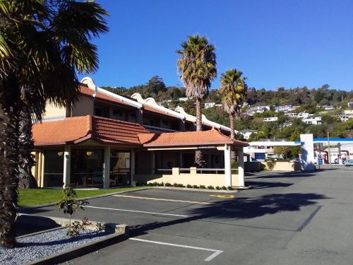 
a large building with palm trees and palm trees at The Beachcomber Hotel in Nelson
