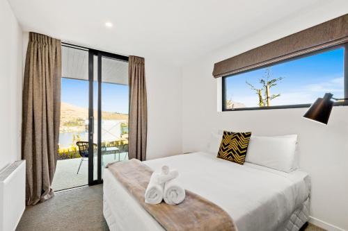 a bedroom with a bed and a large window at Peak View Residence in Queenstown