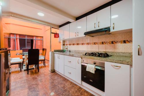 eine Küche mit weißen Schränken und ein Esszimmer in der Unterkunft Hostal Casa del Café in Bogotá