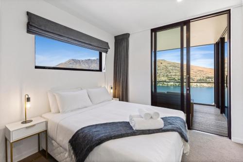 een slaapkamer met een bed en een groot raam bij Remarkable Views in Queenstown