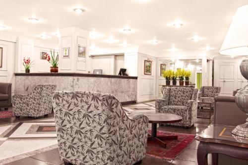 a lobby with chairs and a table and a counter at CHA Prime Curitiba in Curitiba