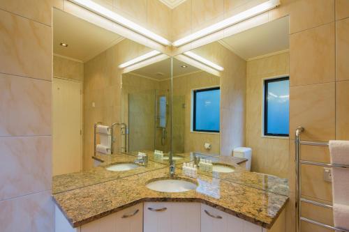 a bathroom with two sinks and a large mirror at Majestic View Home in Queenstown