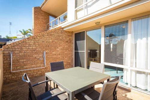 a patio area with a table and chairs at Black Dolphin Motel & Apartments in Merimbula