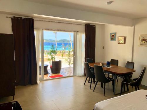 a dining room with a table and a view of the ocean at Sunset Cove Beach & Dive Resort in Romblon