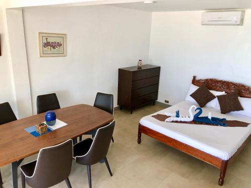 a bedroom with a bed and a table and chairs at Sunset Cove Beach & Dive Resort in Romblon