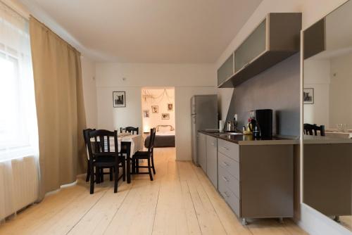 a kitchen and dining room with a table and chairs at Antic Apartments in Bucharest