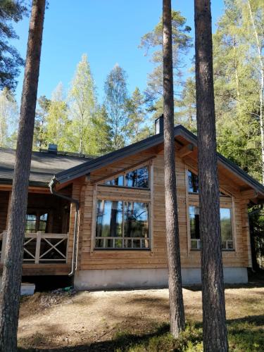 a log cabin in the woods with trees at Rantahuvila Virranniemi in Vehkataipale