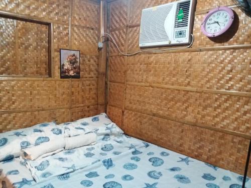 a bed in a room with a clock and a fan at Villa Catalina Leisure resort in Nabas