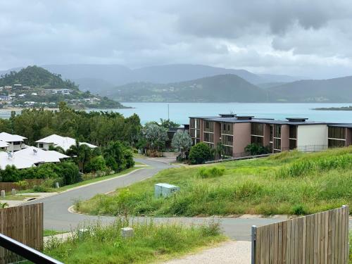 a view of a road with houses and a lake at DAYDREAMING Airlie Beach, Water views & only 200m to boardwalk. in Cannonvale