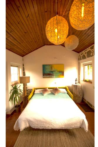 a bedroom with a large white bed with two pillows at A House in The Woods in Sintra