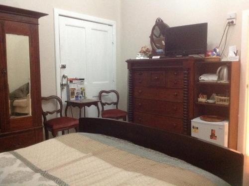 a bedroom with a bed and a dresser with a television at Chinnock B&B in Gilgandra