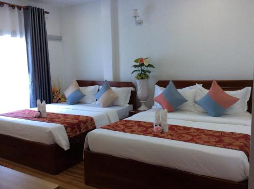 a hotel room with two beds and a window at Realkhom Homestay in Siem Reap