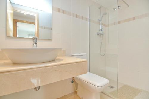 ein Badezimmer mit Waschbecken, Toilette und Dusche in der Unterkunft Jardines de Montemar in Benissa