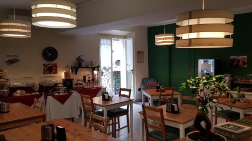 un restaurante con mesas de madera y paredes verdes en Albergo la Svolta, en Brescia
