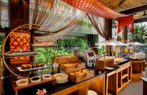 a buffet line with food on display in a restaurant at Astagina Resort Villa and Spa in Legian