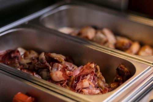 two metal trays filled with meat and vegetables at Vision Premier Hotel & Spa in Hanoi