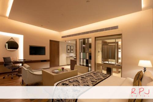 a hotel room with a bed and a living room at RPJ Hotel Rajkot in Rajkot
