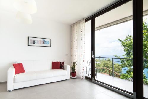a living room with a white couch and a large window at Villa Serra d'Elci in Ascea
