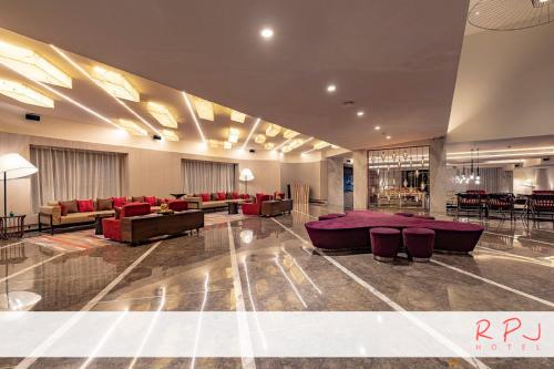 a large lobby with couches and tables and chairs at RPJ Hotel Rajkot in Rajkot