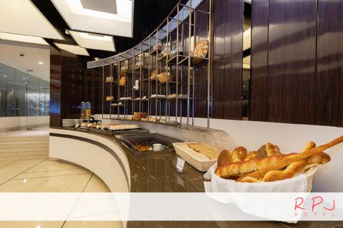 a bakery with a counter with bread and pastries at RPJ Hotel Rajkot in Rajkot