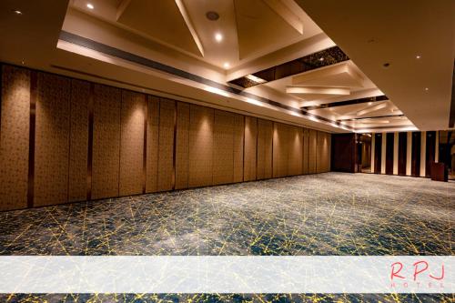 an empty room with wooden walls and a stage at RPJ Hotel Rajkot in Rajkot