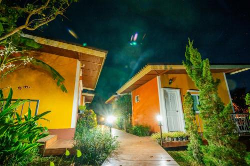 a house with a walkway in front of it at night at The Creek Villa in Loei