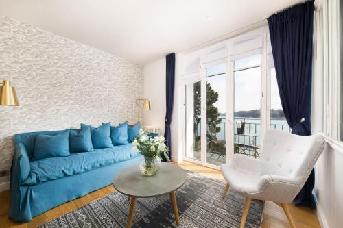 a blue couch in a living room with a window at Restaurant Hotel Didier Méril in Dinard