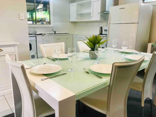 a table with chairs and wine glasses on it in a kitchen at Adelaide Hills Escape in Woodside