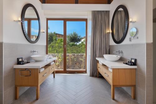 a bathroom with two sinks and a large window at The Setai Sea Of Galilee in Ein Gev
