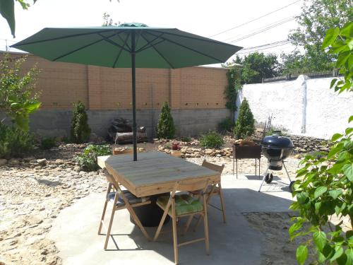 a picnic table with an umbrella in a backyard at Guest House Serena in Chornomorsk