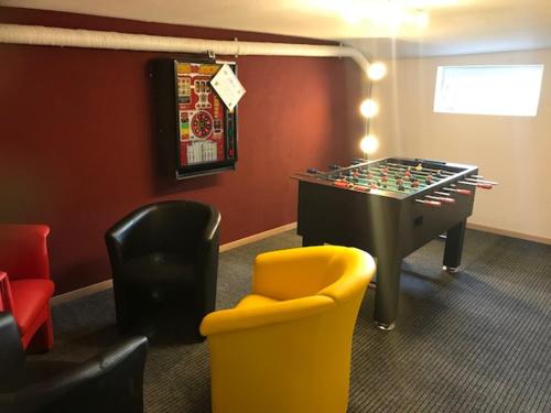 a game room with a foosball table and chairs at Chalet Casa Cresta - Top of Lenzerheide - bis 8 Personen in Valbella