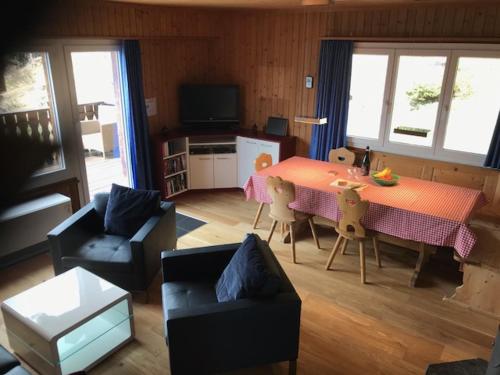 a living room with a table and a dining room at Chalet Casa Cresta - Top of Lenzerheide - bis 8 Personen in Valbella