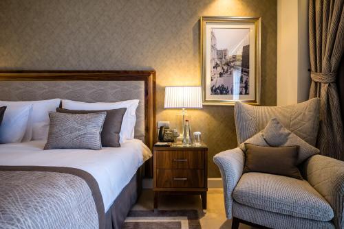 a hotel room with a bed and a chair at Herbert Samuel Jerusalem in Jerusalem