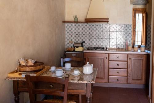 een keuken met een tafel, een wastafel en een fornuis bij Villa Levante in Castelbuono