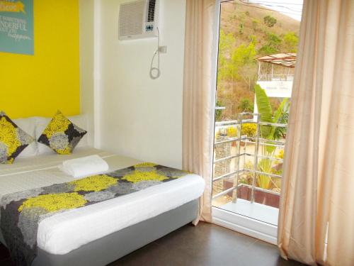 a bedroom with a bed next to a window at Abrhys Ridge Inn in Coron