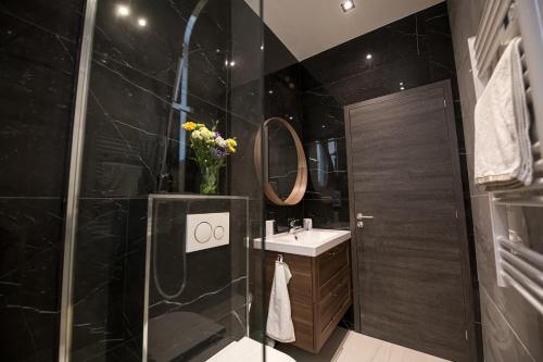 a black bathroom with a sink and a shower at Monaco Central 1 bedroom appartement in Beausoleil