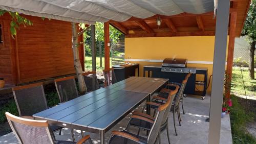 a table and chairs in a patio with a stove at Ilona Prémium Vendégház - Kismaros in Kismaros