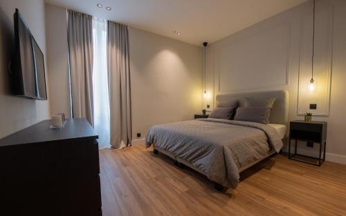 ein Schlafzimmer mit einem Bett, einer Kommode und einem TV in der Unterkunft Monaco Central 1 bedroom appartement in Beausoleil