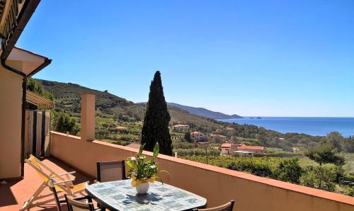 a table on a balcony with a view of the ocean at Mini Appartamenti Elba in Lacona