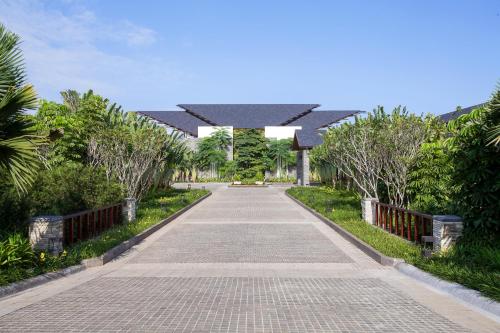 a walkway in a park with trees and bushes at Pullman Ciawi Vimala Hills Resort in Bogor
