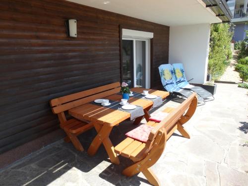a wooden table and two chairs on a patio at Frans Josef Apartments in Seeboden