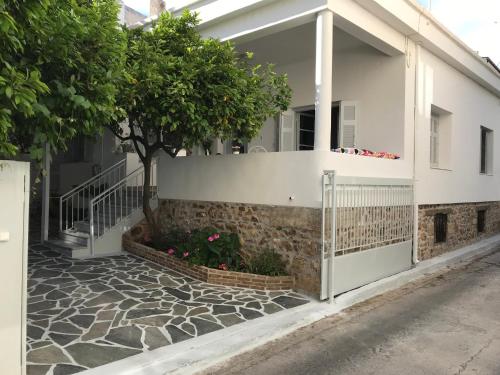 a house with a fence and a tree in front of it at Dina's House in Spáta