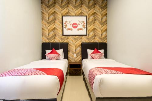 two beds in a room with red pillows at Super OYO 360 Mangaan Residence in Medan