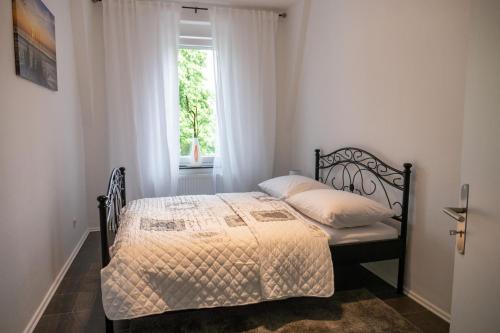 杜伊斯堡的住宿－Appartment Rheinaue，一间卧室设有一张床和一个窗口