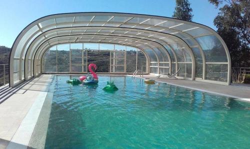 a swimming pool with a glass door and water at Quinta Lagarça 57 in Lagares da Beira