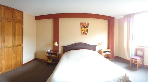 a bedroom with a large bed with a wooden headboard at Qelqatani Hotel in Puno