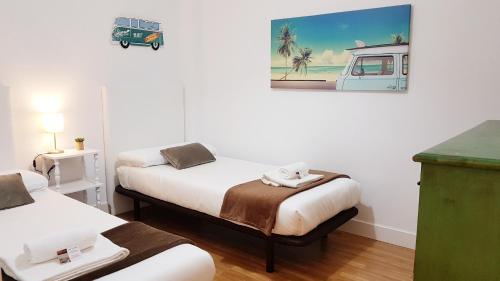 a room with two beds and a painting on the wall at URBIETA CENTRO in Donostia-San Sebastián