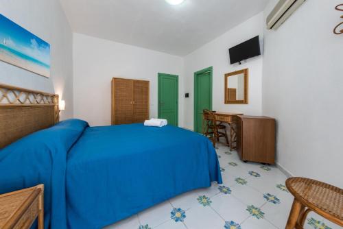a bedroom with a blue bed and a table at Ischia Dream Sunset in Ischia