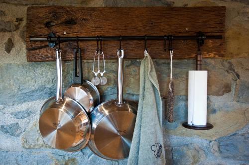 a group of pots and pans hanging on a wall at Can Poca Roba in Sant Pere de Torelló