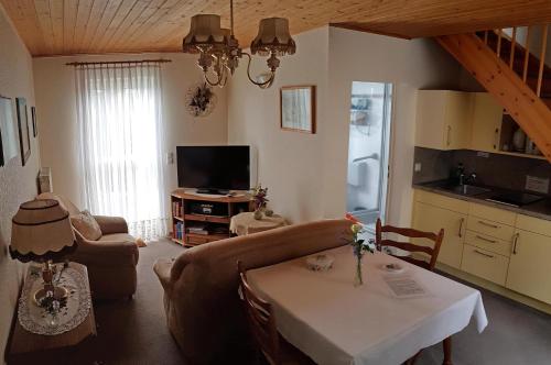 ein Wohnzimmer mit einem Tisch und einer Küche in der Unterkunft Ferienwohnung Gliese in Beeskow